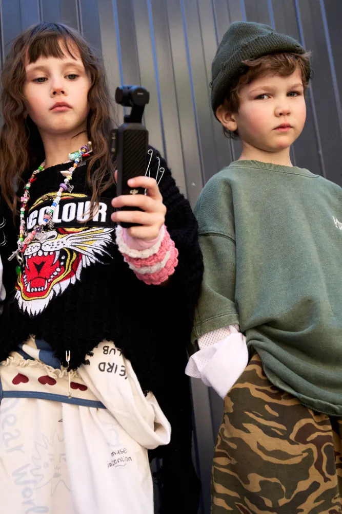 Girl filming with a camera next to a friend